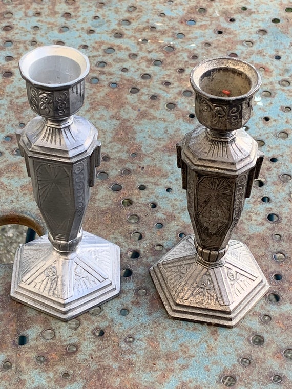 Pair of metal candlesticks, chiseled with a statuette in front, rose pattern in relief, made in France, Art Deco.