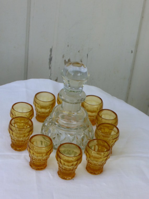 Carafe Transparent glass bottle and 11 small amber yellow glasses