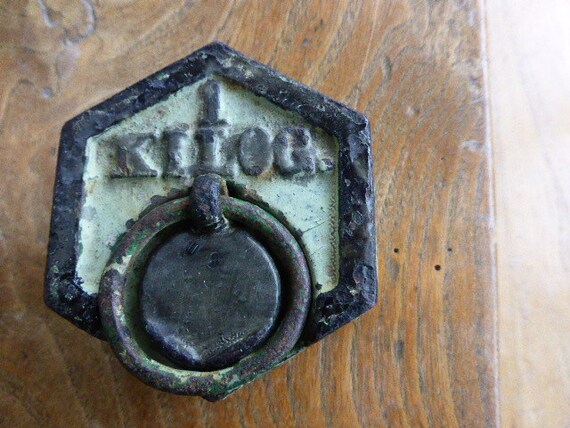 Old cast iron weight of 1 kg for balance of grocery , mint patina of age revealing melting on the edges and on the number