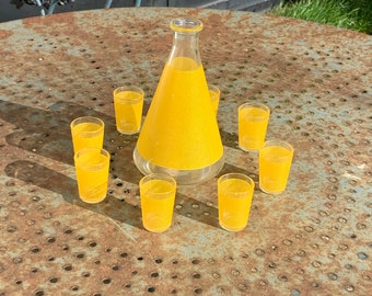 Service a liqueur compose d'une carafe en verre et de 8 petites verres sérigraphies jaune,  effet tissus résille BVB france vintage 1960