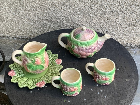 Tea service in enameled ceramic, pink and green fruit slush, consisting of a teapot, a plate, a milk jug and two cups