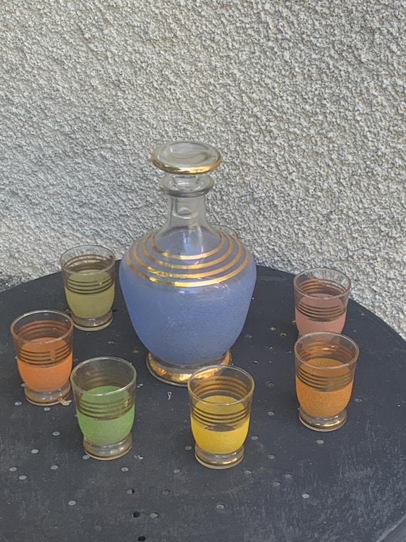 Liqueur set, Port, consisting of a blue granite decanter and 7 yellow, green, pink, and orange glasses with gold trim, vintage 1950s