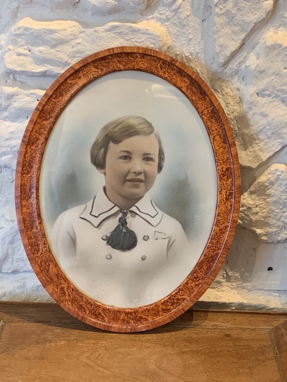 Photograph portrait of a child, old, art deco, in color framed in an oval wooden frame