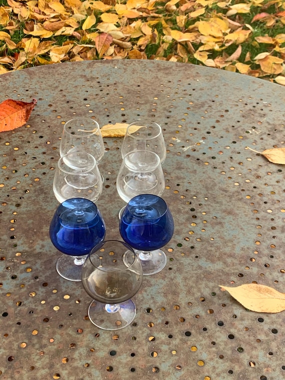 7 cognac glasses, in colored glass, 2 blue, one gray and 4 transparent ARC France, vintage