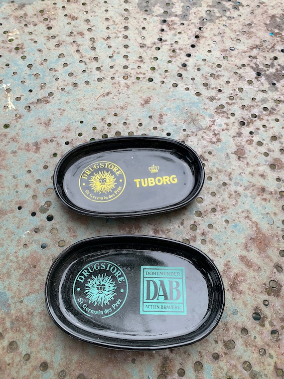 Lot of two advertising ashtrays, Tuborg and DAB, St Germain des Prés drugstore in black opalex, glass, vintage