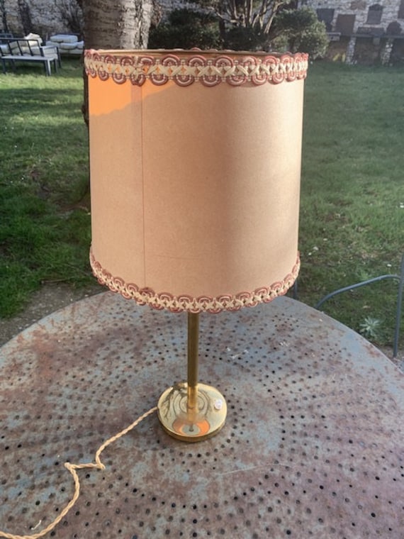 Table lamp, bedside lamp in gilded brass, column feet, beige lampshade with trimmings, vintage