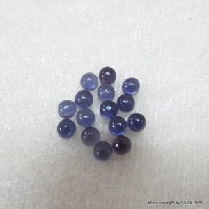 May include: A collection of 17 round, smooth, purple gemstones. The gemstones are approximately 5mm in diameter.