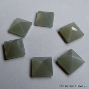 Puede incluir: Seis cabujones de piedra preciosa gris en forma de pir&aacute;mide, cada uno con una base cuadrada.