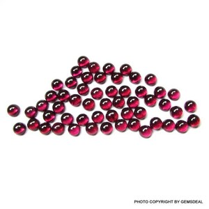 May include: A group of 40 round, red, glass cabochons. The cabochons are scattered on a white surface.