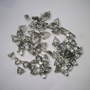 May include: A collection of black tourmaline gemstone points, also known as black quartz, in a triangular shape. The stones are clear with black inclusions.