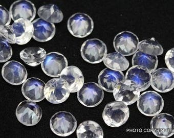 May include: A collection of round, iridescent moonstone gemstones. The stones are a milky white color with a blue sheen.