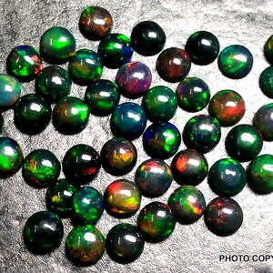 May include: A collection of 40 round, black opal cabochons with green, red, and blue iridescent flashes. The opals are approximately 6mm in diameter.
