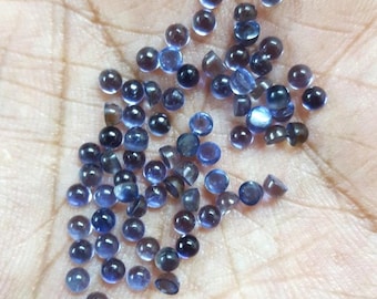 May include: A collection of small, round, blue gemstones. The gemstones are smooth and have a slight sparkle.