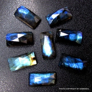 Peut inclure: Huit pierres précieuses de labradorite facettées de forme rectangulaire. Les pierres sont d'un bleu foncé avec des reflets irisés.