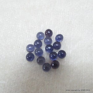 May include: A collection of 16 round, smooth, purple-blue gemstone beads. The beads are approximately 5mm in diameter and have a polished finish.