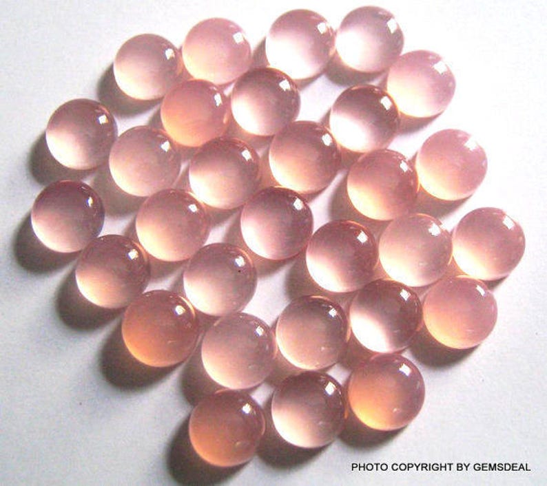 Pu&ograve; includere: Una collezione di 25 pietre preziose rotonde, traslucide e rosa. Le pietre preziose sono lisce e lucidate, con un leggero luccichio.