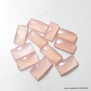 Peut inclure: Dix cabochons de pierres précieuses rectangulaires facettées de couleur rose pâle. Les pierres sont translucides et ont un aspect légèrement nuageux.