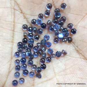 Puede incluir: Una colecci&oacute;n de peque&ntilde;as piedras preciosas redondas azules. Las piedras preciosas son lisas y tienen un ligero brillo.