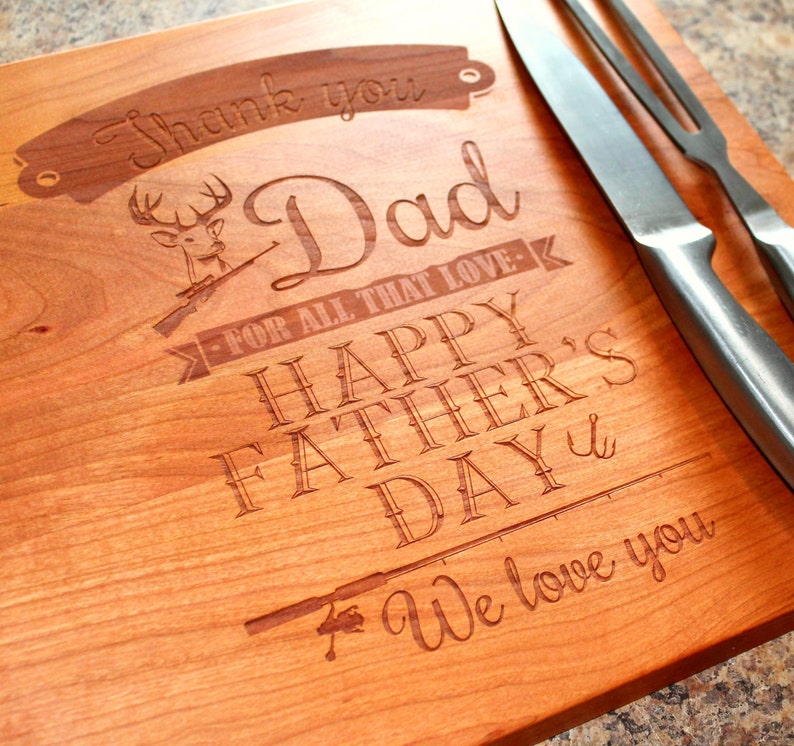 May include: A wooden cutting board with a laser engraved message that reads "Thank you Dad for all that love - Happy Father's Day - We love you". The board features a deer with antlers and a fishing rod.