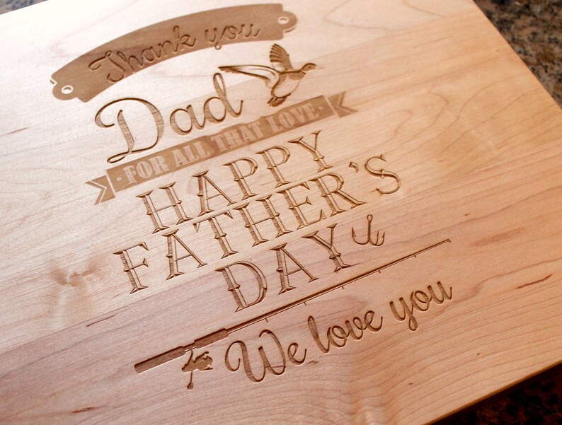May include: A wooden cutting board with an engraved message that reads "Thank you Dad - For all that love - Happy Father's Day - We love you". The message is surrounded by a decorative border and includes a small image of a bird.