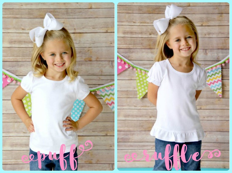 May include: Two photos of a young girl wearing a white t-shirt with a ruffle at the bottom. The girl on the left is wearing a white bow in her hair and the girl on the right is wearing a white bow with a ruffle. Both girls are standing in front of a wooden background with a colorful garland.
