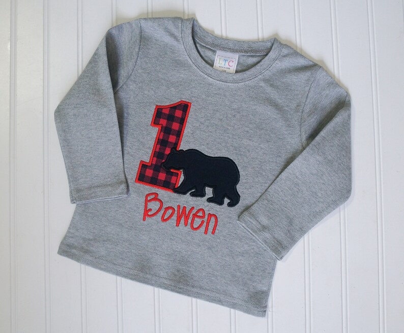 May include: Gray long-sleeve shirt with a red and black plaid number one and a black bear silhouette. The shirt is personalized with the name "Bowen".