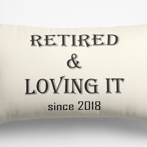 May include: A white rectangular pillow with black text that reads "Retired & Loving It since 2018".