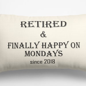 May include: A white throw pillow with black text that reads "Retired & Finally Happy on Mondays since 2018".