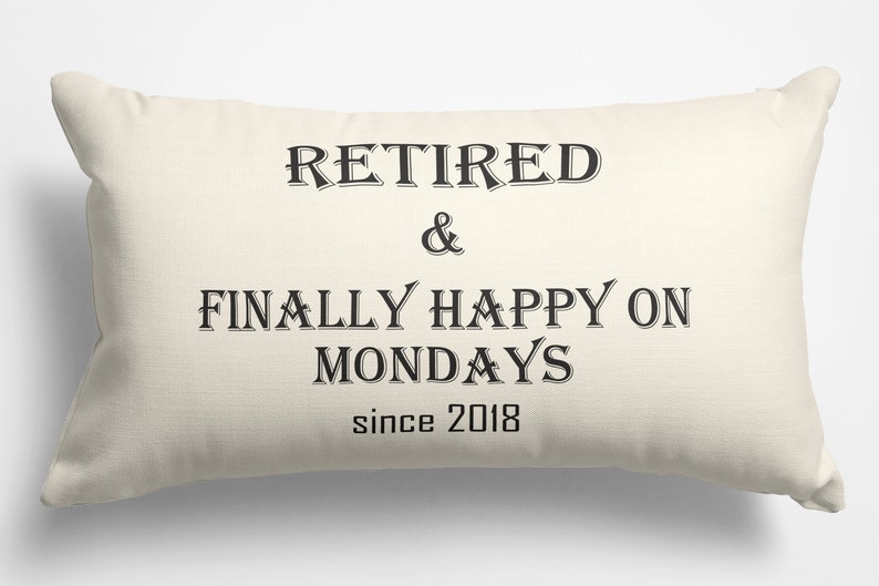 May include: A white throw pillow with black text that reads "Retired & Finally Happy on Mondays since 2018".