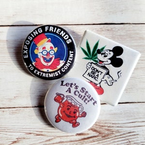 May include: Three vintage pinback buttons with humorous designs. One features a clown with the text "Exposing Friends to Extremist Content." Another shows Mickey Mouse with a cannabis leaf and the words "Don't Be a Narc." The third says "Let's Start a Cult!"
