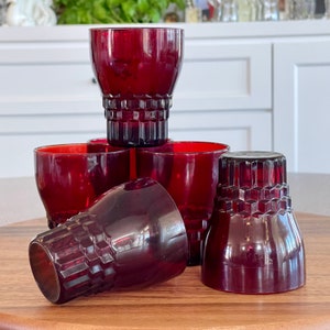 May include: Set of five ruby red glass tumblers with a diamond pattern. The glasses are stacked on top of each other.