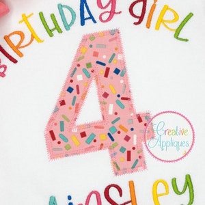 以下が含まれることがあります： 虹色の刺繍が施された誕生日女の子のデザインが施された白いTシャツ。デザインには、ピンクの背景とカラフルなスプリンクルが施された数字の4、