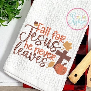 May include: White kitchen towel with embroidered text "Fall for Jesus he never leaves" in brown and orange. The embroidery includes a cross, a pumpkin, and leaves.