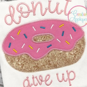 Op de afbeelding: Een roze en bruine donut met sprankelingen en de tekst "donut give up" geborduurd op een witte stof.