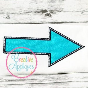 May include: A turquoise blue arrow with a black outline, stitched on a white fabric background. The arrow points to the right. The text "Creative Appliques" is visible in a circle below the arrow.