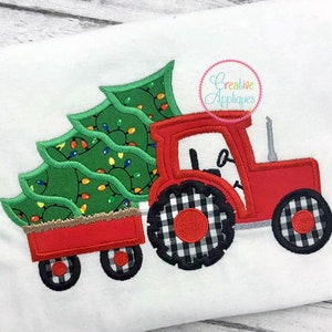 Może przedstawiać: Czerwony traktor zabawka z czarno-białymi kołami w kratkę ciągnie czerwony wóz z zielonym drzewem bożonarodzeniowym ozdobionym światełkami.
