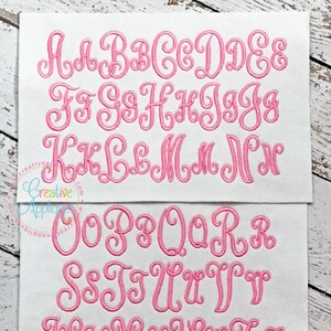 May include: A full alphabet of pink cursive letters with a decorative flourish on each letter. The letters are embroidered on a white fabric background.