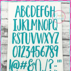 Pode incluir: Um conjunto de letras, números e símbolos de fonte de bordado azul turquesa. A fonte é de estilo manuscrito. As letras são de A a Z, os números são de 0 a 9 e os símbolos são !@#$&0/?:. O texto abaixo da fonte diz "6 tamanhos: 0,75"/1"/1,25"/1,5"/1,75"/2" ".