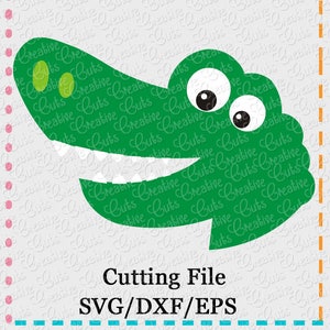 May include: Green alligator head with a toothy grin and large, round eyes. The alligator head is a digital cutting file for crafting projects. The text "Cutting File SVG/DXF/EPS" is below the alligator head.
