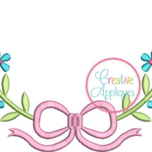 May include: A floral design featuring a pink bow at the bottom and two green stems curving upwards, each adorned with blue and pink flowers. The design includes the text "Creative Appliques" in a circle.
