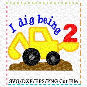 May include: A yellow toy construction vehicle with a blue "I dig being 2" text and a red number 2. The vehicle is on a brown dirt background.