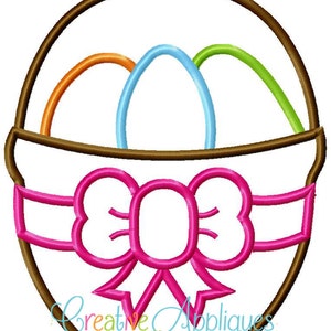 May include: A brown Easter basket with a pink bow and three colourful eggs inside. The eggs are orange, blue and green.