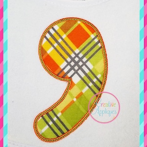 Può includere: Una grande applique in tessuto a quadri arancio, giallo e verde a forma di numero nove. L'applique è bordata con filo arancione.