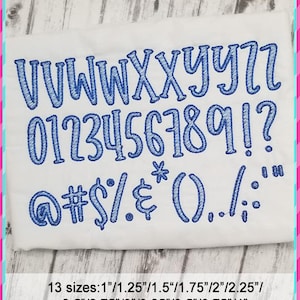 May include: A white fabric with blue embroidered letters, numbers, and symbols. The letters are in a casual, handwritten style. The text includes the alphabet, numbers 0-9, punctuation marks, and symbols. The text reads "VVWWXXYYZZ 0123456789!? @#$%&*()../;;"  The text is followed by "13 sizes: 1"/1.25"/1.5"/1.75"/2"/2.25"/ 2.5"/2.75"/3"/3.25"/3.5"/3.75"/4"