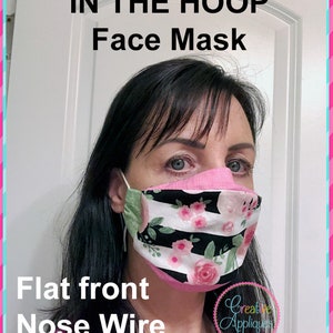 May include: A pink and black face mask with a floral pattern and a nose wire. The mask is flat on the front and has the text "IN THE HOOP Face Mask" and "Flat front Nose Wire" on the image. The text "Creative Appliques" is also visible on the image.