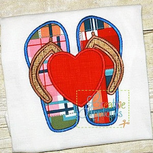 May include: Embroidered design of two flip flops with a red heart in the center. The flip flops are patterned with plaid and have blue outlines.