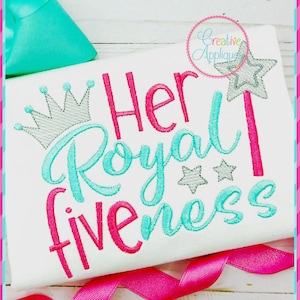 May include: Embroidered design on a white shirt with the text "Her Royal Highness" in pink and turquoise lettering. A silver crown and stars are also embroidered on the shirt.