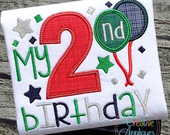 Puede incluir: Una camiseta blanca con el texto "My 2nd Birthday" bordado en verde, rojo, plateado y azul. El número 2 es grande y rojo. Hay dos globos verdes y azules con el texto "2nd" en uno de ellos.