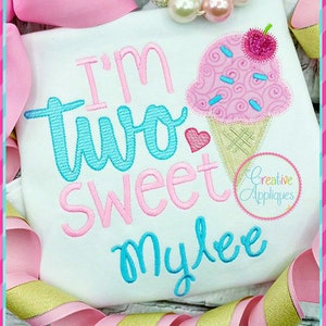 May include: A white onesie with pink and blue embroidery that reads "I'm two sweet Mylee" with a pink and white ice cream cone graphic.