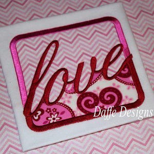 May include: A white fabric square with a pink and white chevron pattern background. A red embroidered frame surrounds the word "love" in a cursive font. The text "Daffe Designs" is in the bottom right corner.